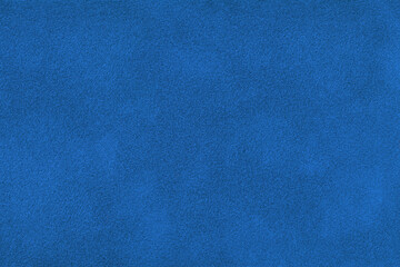 Dark blue suede fabric background with matte nap velvet texture. Royal blue tones and soft felt textile surface in macro