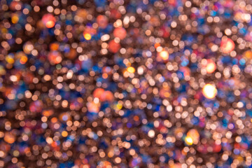 Background with many bright lights with bokeh effect and soft shades of blue, yellow, and red.