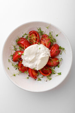 tomatoes with buratta cheese on a white background