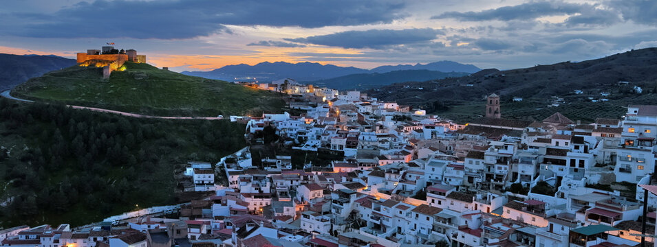 Moorish castle and vialleg of Alora in Andalusia, Spain, under a cloudy sky at sunset, in a wet and green winter