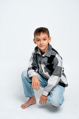 a boy child on a white isolated background, a teenager in jeans and a shirt