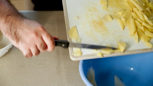Slicing potatoes in a kitchen for cooking preparations with simple tools