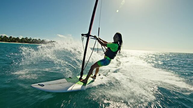 Woman windsurfing on ocean waves sport.