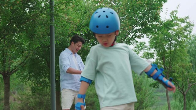 Dad taking kids skateboarding in the park