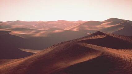 Naklejka premium Soft curves of sand dunes create an endless horizon as the warm glow of sunset bathes the desert in golden light, showcasing nature’s serene beauty and vastness.