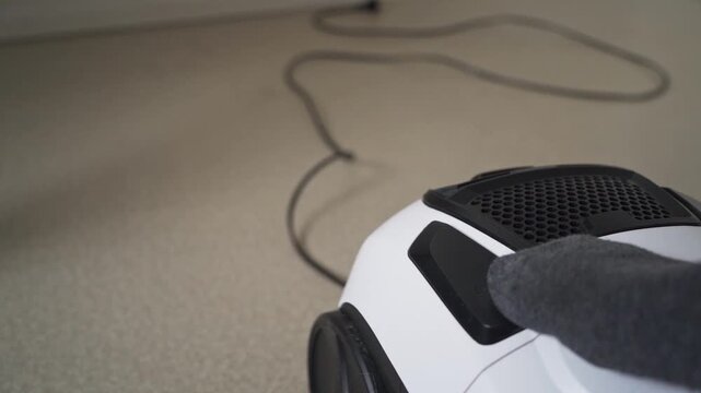Retracting power cord of vacuum cleaner close up in slow motion