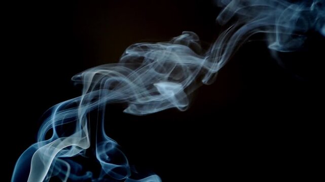 Abstract smoky wisps gently dance against a black backdrop, creating an artistic display of movement and ethereal textures. This captivating scene evokes a sense of mystery and transience