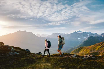 Couple friends hiking in Norway man and woman travel together explore mountain trails, active summer vacations healthy lifestyle family trekking outdoor extreme adventure trip in Lofoten islands © EVERST