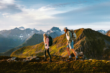 Obraz premium Couple friends climbing mountains in Norway man and woman family travel together healthy lifestyle endurance, people on active hiking summer vacation trip outdoor adventure holidays in Lofoten islands