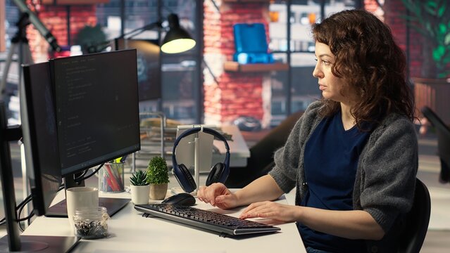 Woman IT developer using pc setup for artificial intelligence cloud computing through self learning algorithms. Agency system engineer works with AI deep neural networks on desktop. Camera B.