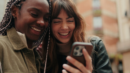 Happy Lesbian Couple Laughing While Looking at Phone