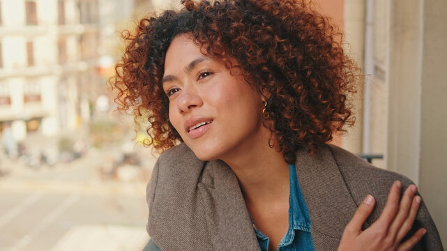 Confident Woman With Curly Hair In Blazer On Balcony