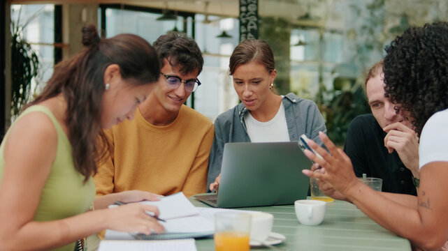 Friends Studying Together At Table With Laptop
