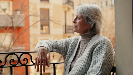 Fototapeta premium Contemplative Elderly Woman On City Balcony