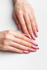 Naklejka premium Woman hands manicure with long glittery rose gold nails