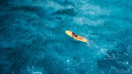 Woman on surfboard in blue sea. Drone view of surfer during surfing © artifirsov