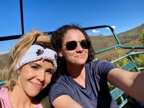 Two smiling woman sitting side by side on a chair lift in summer, Sundance, Utah, USA
