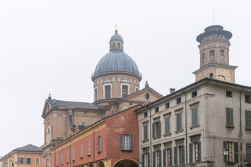 Fototapeta premium Historic church dome above city rooftops in rainy weather in Reggio Emilia, Italy