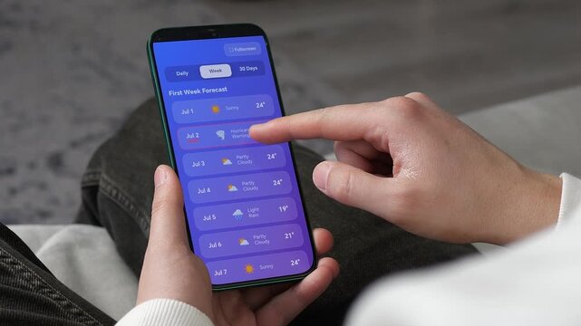 Finger tapping on a digital weather interface to see the weekly forecast. High-quality UI design showing a drop in temperature and storm notification. Concept of mobile internet, smart applications
