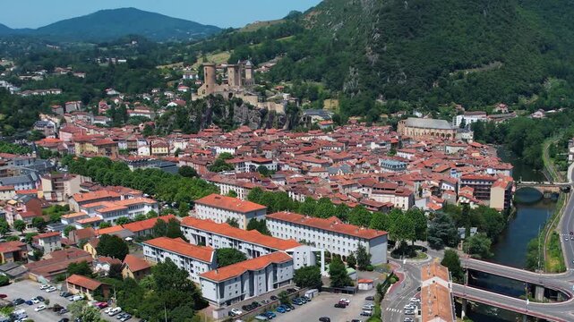 An aerial view around the old town in the city Foix on a sunny summer noon in France .