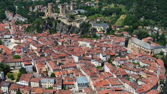 An aerial view around the old town in the city Foix on a sunny summer noon in France .