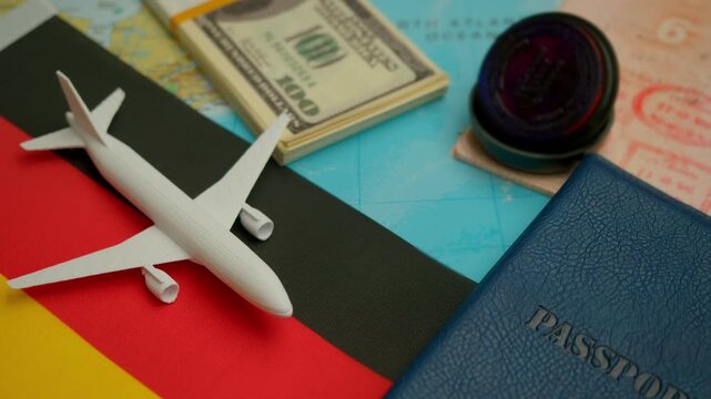 Travel concept with airplane, stamped passport, and money over world map showing Germany flag, symbol of European business and tourism.