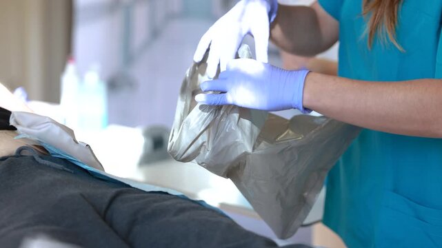 Nurse preparing disposal bag for ostomy pouch change following hygiene protocol and safe waste management practice