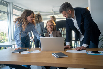 Naklejka premium Casual meeting of smiling diverse business team analyzing financial data