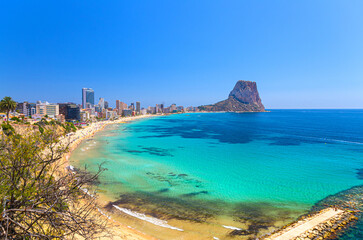 Calpe town coastline aerial view panorama Costa Blanca coast with mountain Penon de Ifach, sandy beach, Calpe bay Mediterranean Sea with azure water in sunny summer day, Valencian Community, Spain