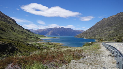 Obraz premium Scenic Mountain Lake View from Winding Road with Guardrail, Lake Hawea, New Zealand