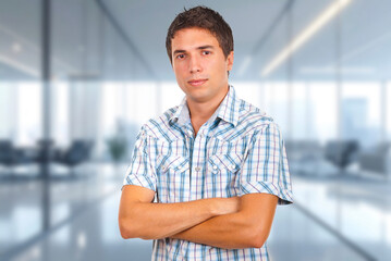Obraz premium Young man stands confidently with crossed arms