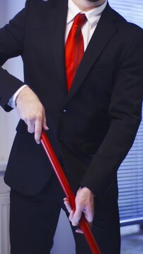 Headless Businessman with red tie clean the floor doing housework