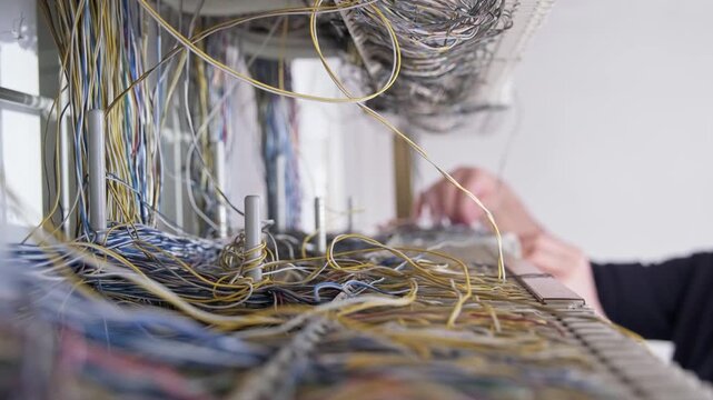 Close up of telecommunications connectors with cross connected copper pair cables on terminal blocks in a distribution frame inside a telecom technical room.
