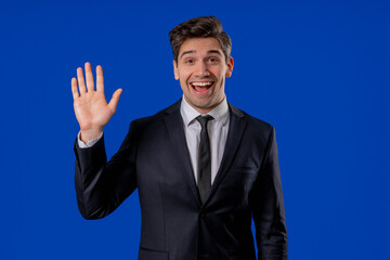 Friendly Mature 30s aged businessman Waving Hand - Hello, Hi, salute, chao. Greetings on blue studio. © kohanova1991