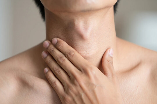 Person touching neck with visible swelling or lump on throat hand