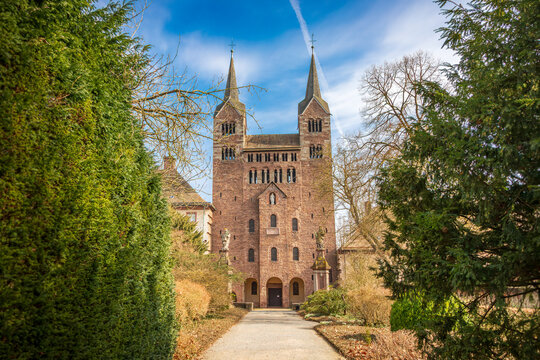 Carolingian Westwork of Corvey Abbey, Germany. UNESCO World Heritage site featuring medieval towers and sandstone architecture framed by green trees under a blue sky in Hoxter.