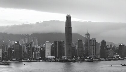 Fototapeta premium Hong Kong skyline at dusk with towering skyscrapers and harbor view in black and white