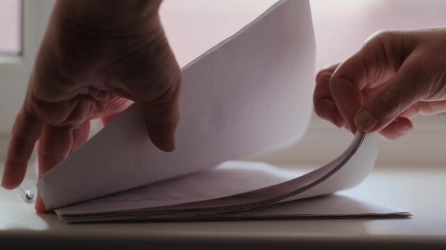 Close-up of a woman's hands working with documents in an office