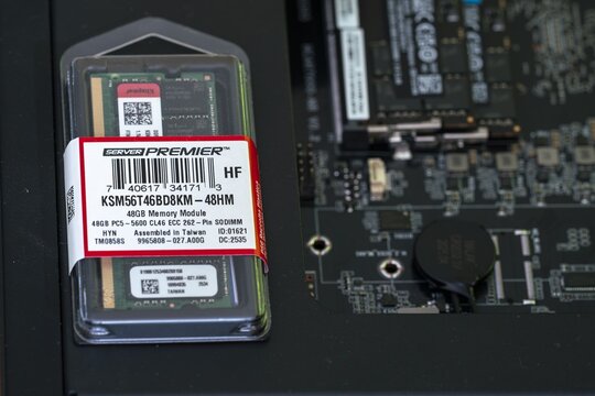 Close-up of a 48GB DDR5 ECC SODIMM memory module for AI and data centers in protective packaging, labeled Server Premier, placed next to a server motherboard circuit board.