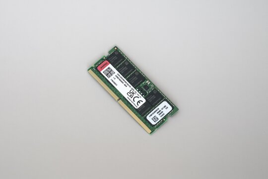 DDR5 ECC RAM Memory Module for AI and data centers on White Background. Close-up of a green DDR5 ECC RAM stick with white labels and gold contacts, isolated on a plain white surface.