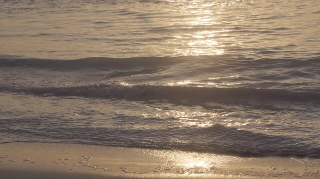 Slow motion footage of ripples of sea water on the seashore during golden hour sunset. 4K, 24 fps, h265, 10 bit.	