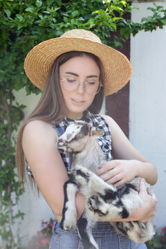 Young Woman With Baby Goats on Countryside Farm &ndash; Rural Lifestyle, Animal Care, Wellbeing and Slow Living Concept
