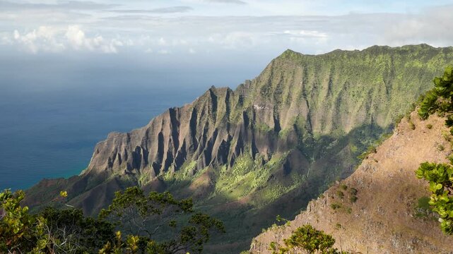 The towering cliffs and lush green valley of the Napali Coast from above, Kauai, Hawaii. Breathtaking view of Kauai natural beauty. High quality 4k footage