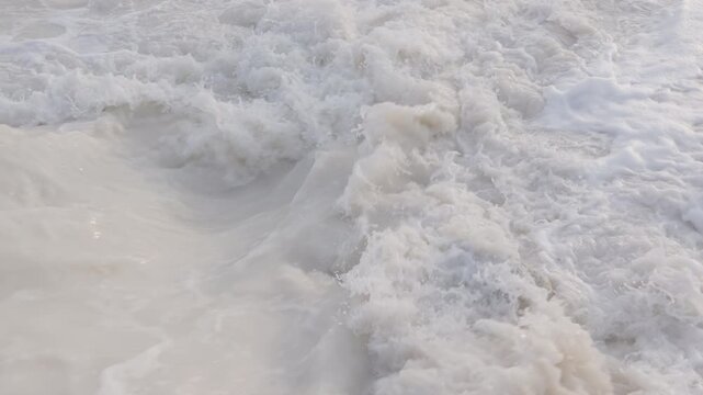 Polluted white foamy water from industrial drain in slow motion. 4K, 24 fps, h265, 10 bit