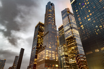 Modern glass skyscrapers of Hudson Yards rise into a cloudy evening sky in Manhattan, New York. © Jose Luis Stephens