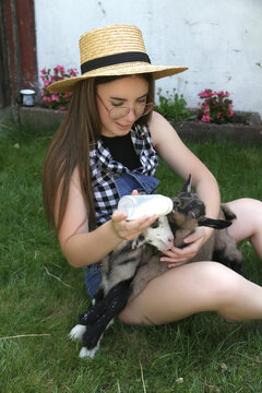 Young Woman With Baby Goats on Countryside Farm &ndash; Rural Lifestyle, Animal Care, Wellbeing and Slow Living Concept