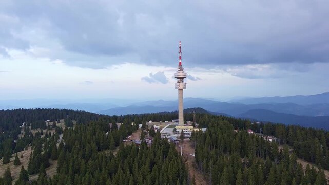 Tower Snezhana on peak of Snezhana covered with spruce forests in Rhodope mountains