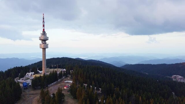 Tower Snezhana on peak of Snezhana covered with spruce forests in Rhodope mountains