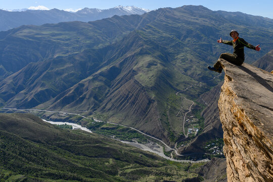 Adventurous person enjoying the stunning view from a mountain cliff. Goor, Dagestan, Russia.