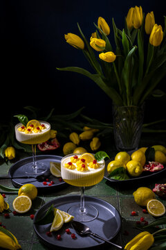 Lemon panna cotta dessert with fresh pomegranate and yellow tulips
